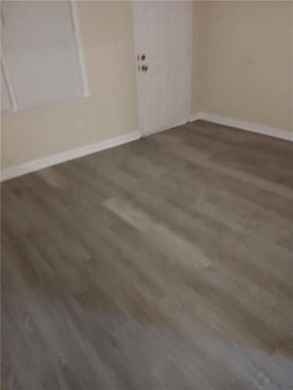 Unfurnished room with dark wood-type flooring