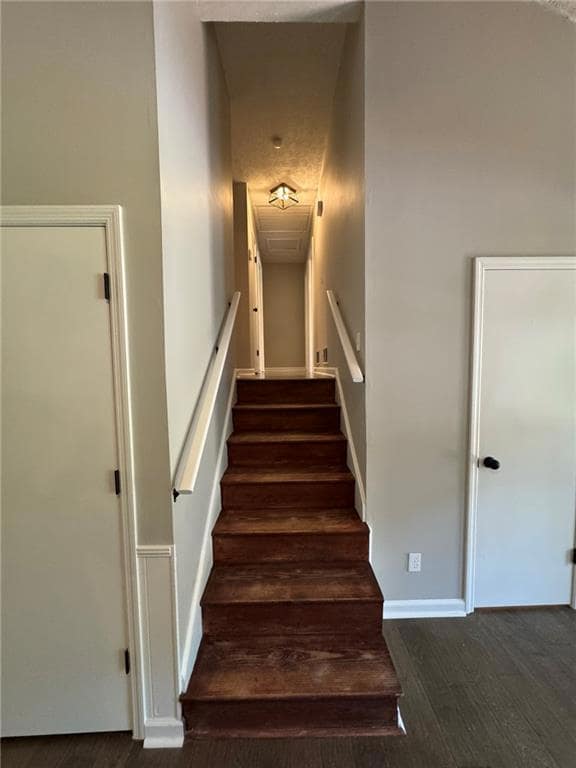Staircase featuring wood finished floors and baseboards
