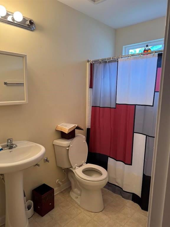 Bathroom with toilet and a shower with curtain