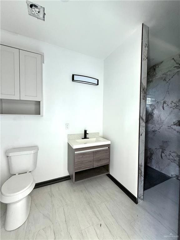 Full bathroom with a marble finish shower, toilet, vanity, baseboards, and marble finish floors