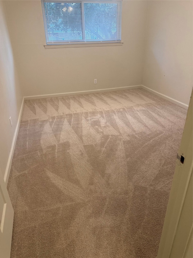 Unfurnished room featuring light colored carpet and baseboards