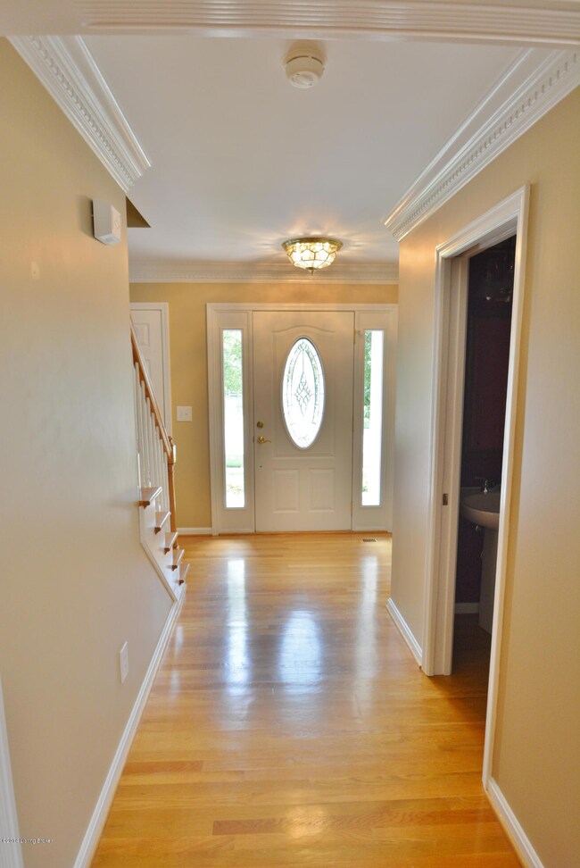 Foyer has crown molding and BEAUTIFUL wood floors.
