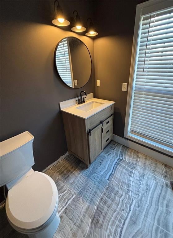 Remodeled half bath with new sink, mirror, toilet, tiled flooring and lighting