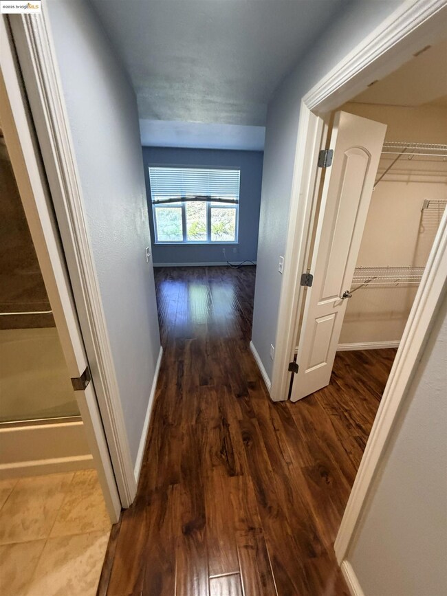 Hall with dark wood-style floors and baseboards