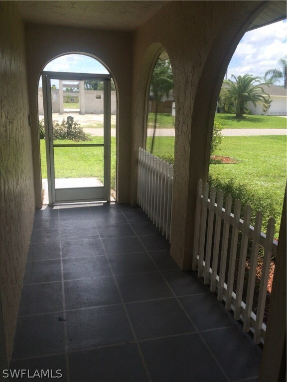 Front entry way is screened with tile and decorative fence.