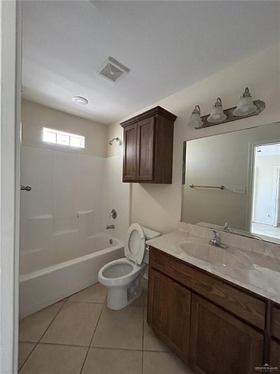 Bathroom featuring tile patterned floors, washtub / shower combination, vanity, and toilet