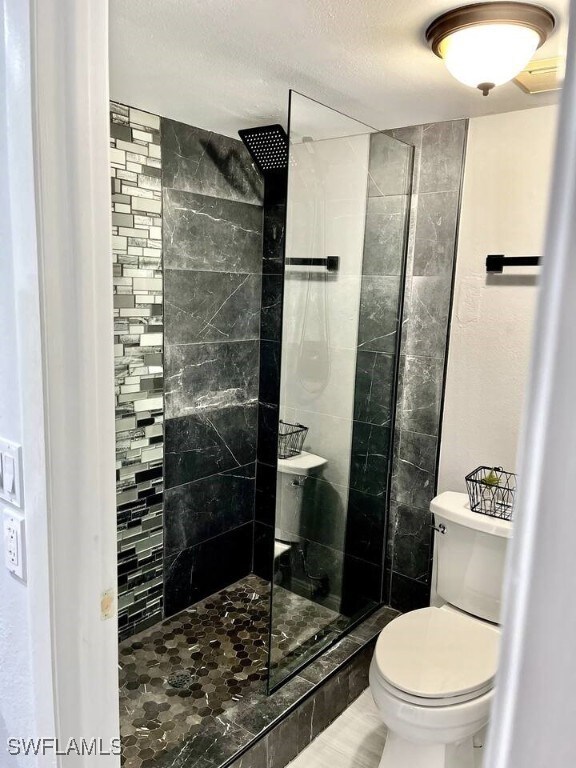 Bathroom with a shower stall and a textured ceiling