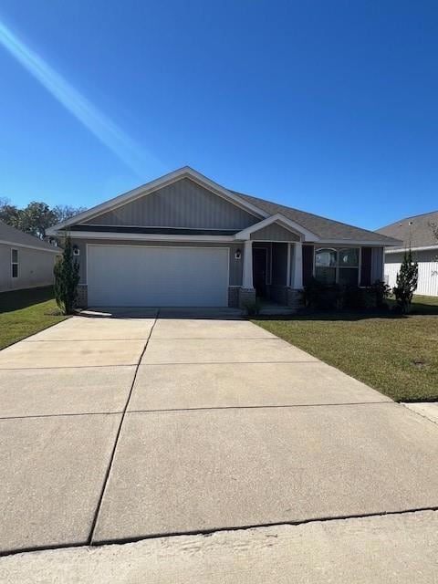 Craftsman house featuring driveway, a garage, and a front lawn