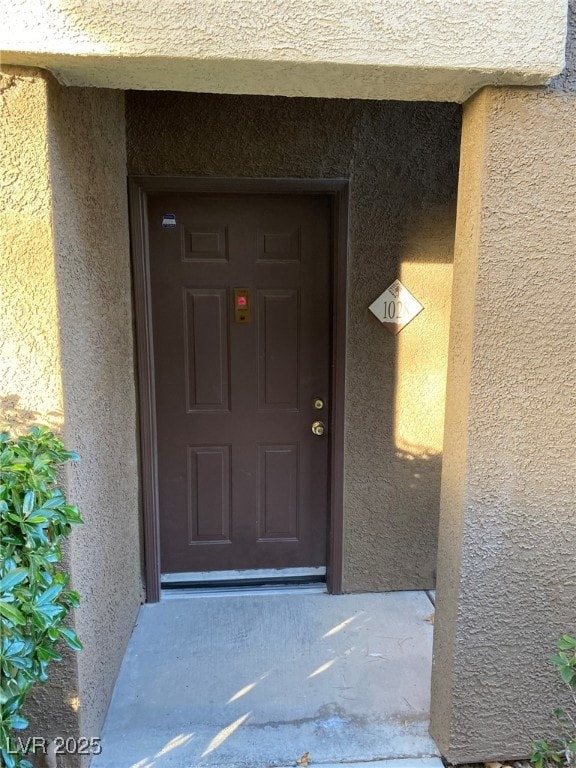 Doorway to property with stucco siding