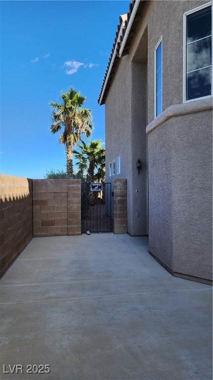 View of patio featuring a gate