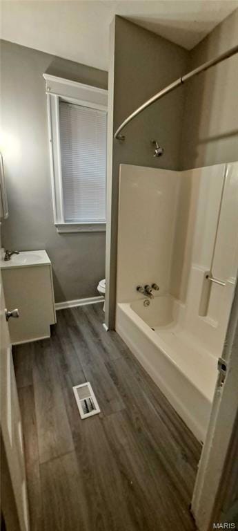 Full bathroom with vanity, shower / washtub combination, and dark wood-type flooring