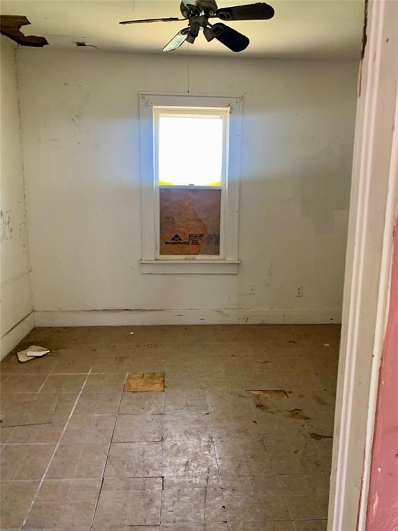 Empty room featuring ceiling fan and tile patterne