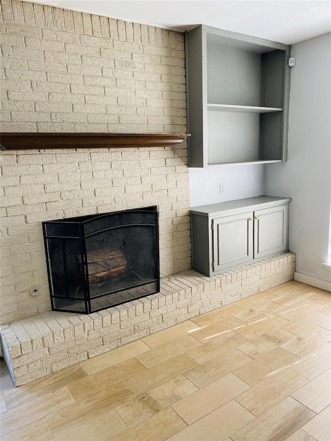 Details with a brick fireplace, baseboards, and w