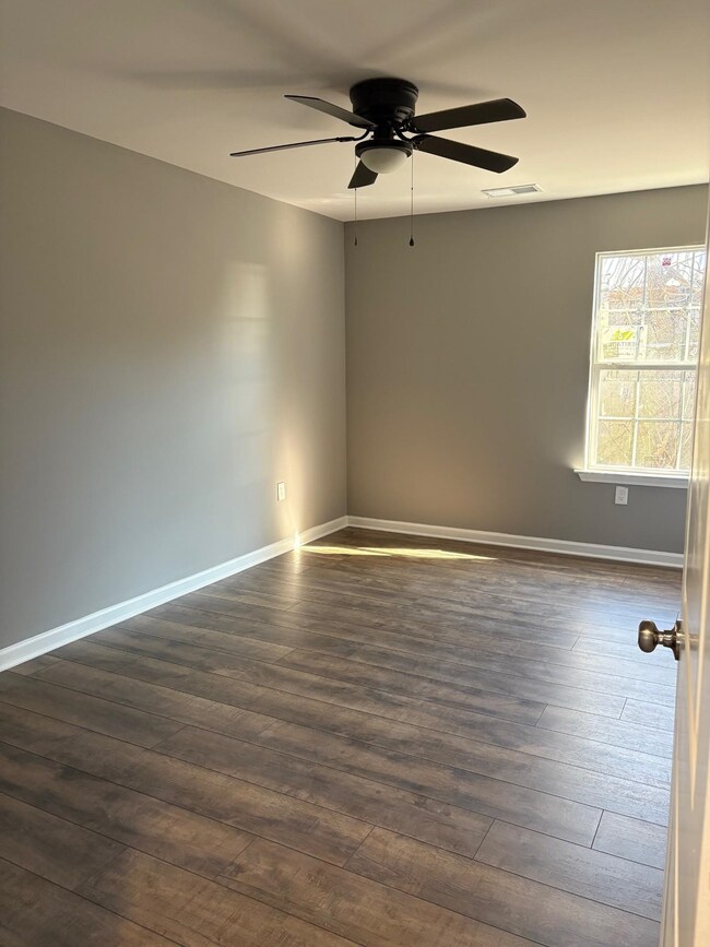 Spare room with dark wood-type flooring and ceilin