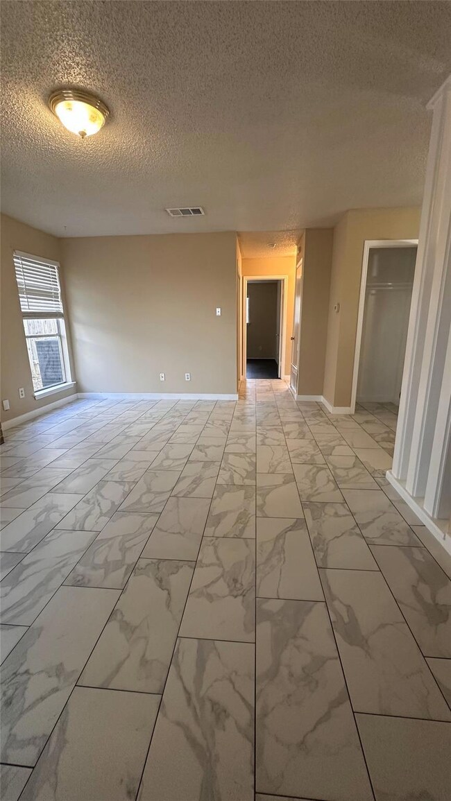 Unfurnished room featuring a textured ceiling and