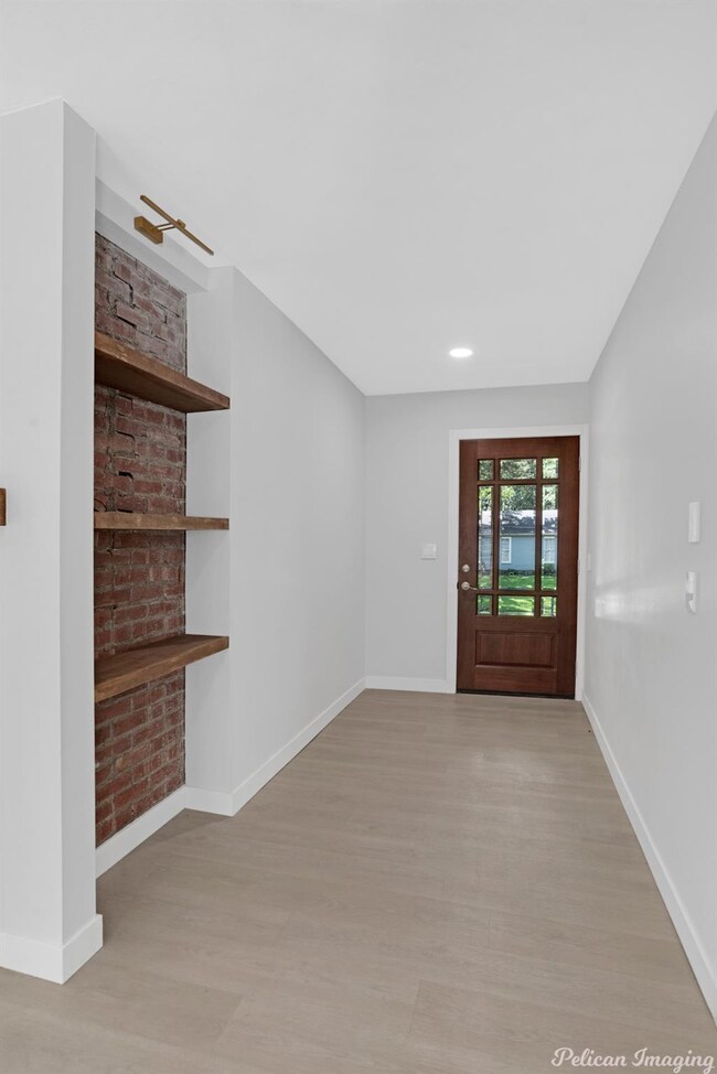 Entry way with exposed brick shelving and a glass 