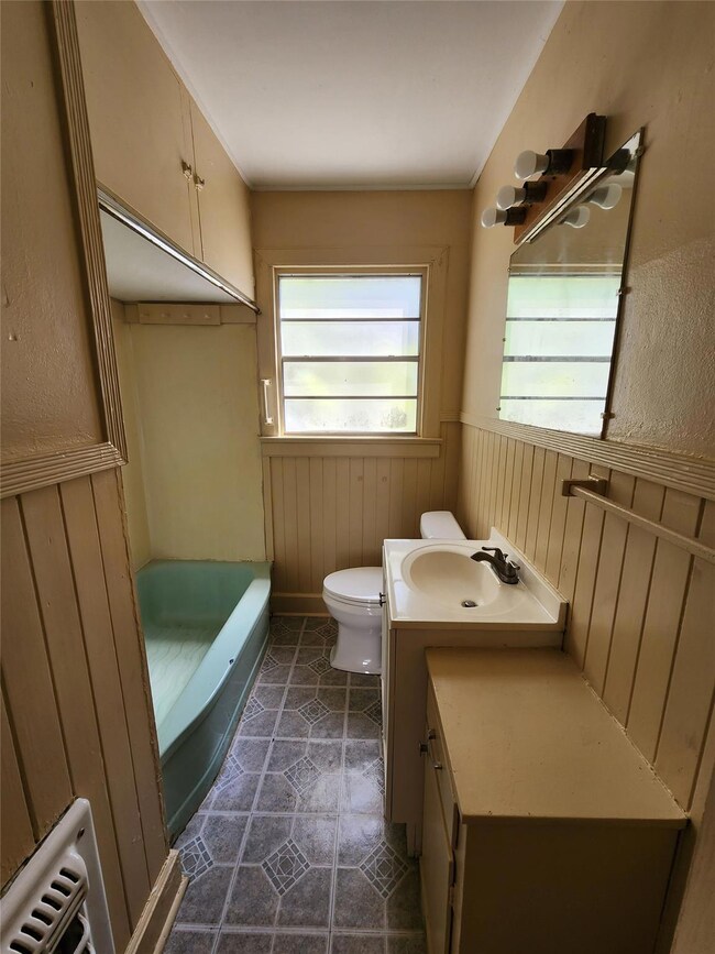 Bathroom with tile flooring, radiator heating unit