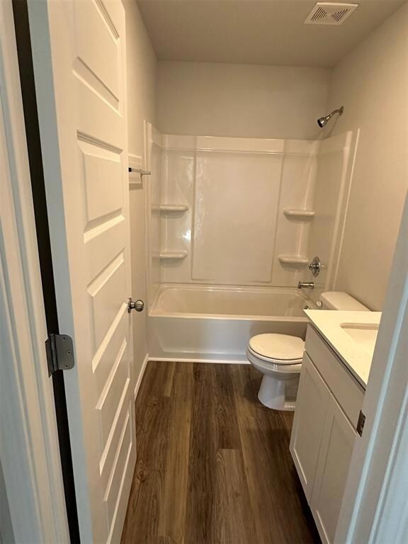 Bathroom featuring toilet, wood finished floors, v