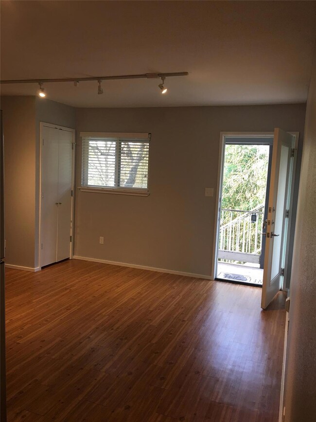 Unfurnished room with rail lighting, dark wood-st