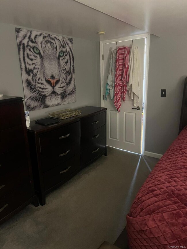 Bedroom with light colored carpet and baseboards