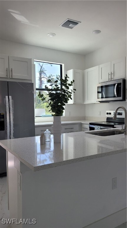 Kitchen featuring refrigerator, light stone counte