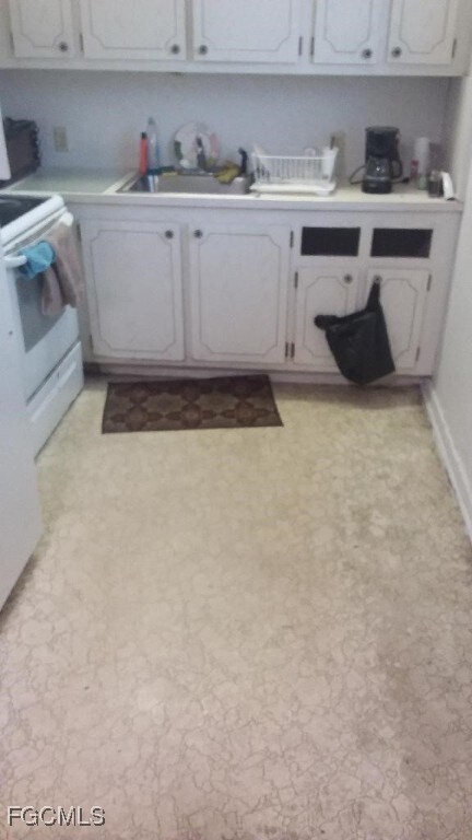 Kitchen with white electric range oven, light coun