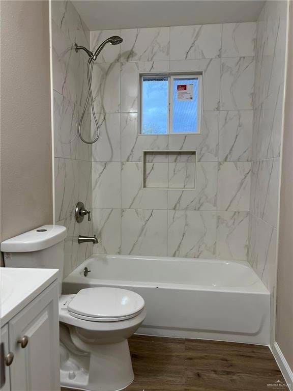 Bathroom with dark wood-style floors, shower / bath combination, and vanity