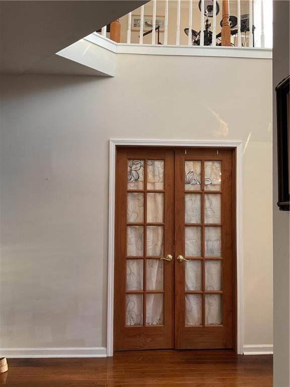 Entryway with french doors and dark wood-type floo