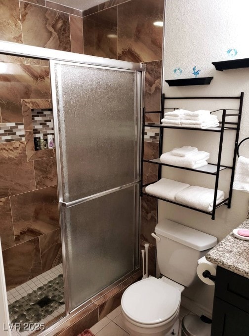 Bathroom with toilet, a shower stall, and vanity