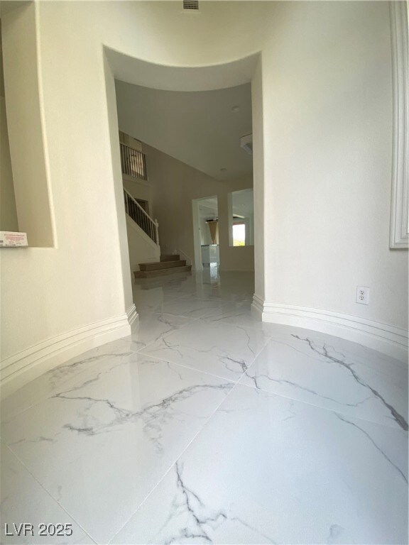 Unfurnished room with stairs, visible vents, marbl