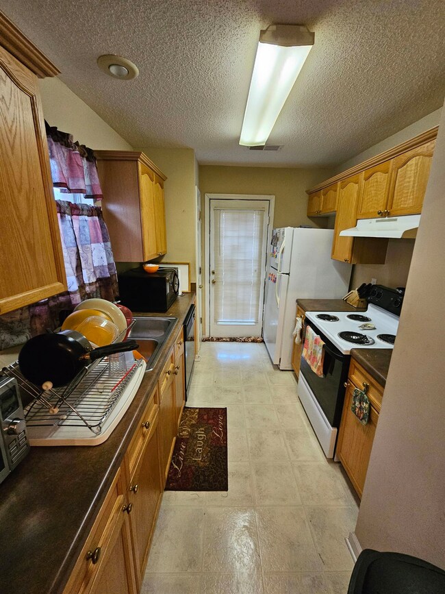 Kitchen featuring a textured ceiling and black app