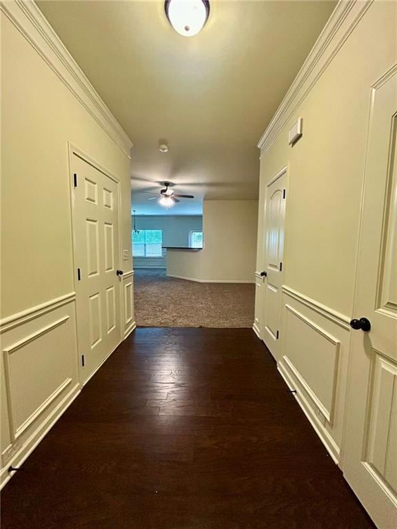 Corridor featuring dark wood-style flooring and ornamental molding