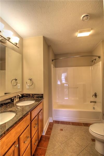 Guest Bath featuring dual sinks, ceramic tile floo
