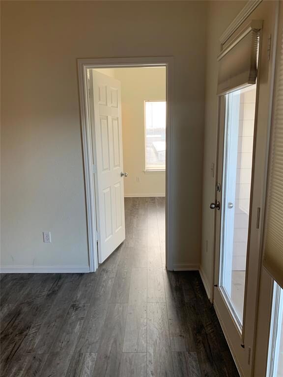 Hall with dark hardwood / wood-style flooring
