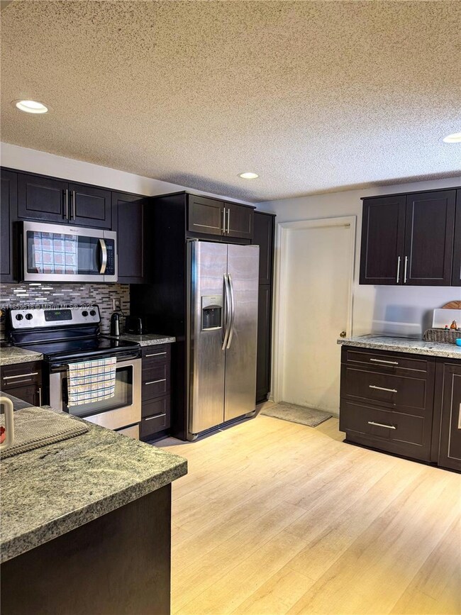 spacious, renovated kitchen equipped with premium stainless steel appliances. Designed for both style and functionality, the open layout offers the perfect setting to entertain guests,