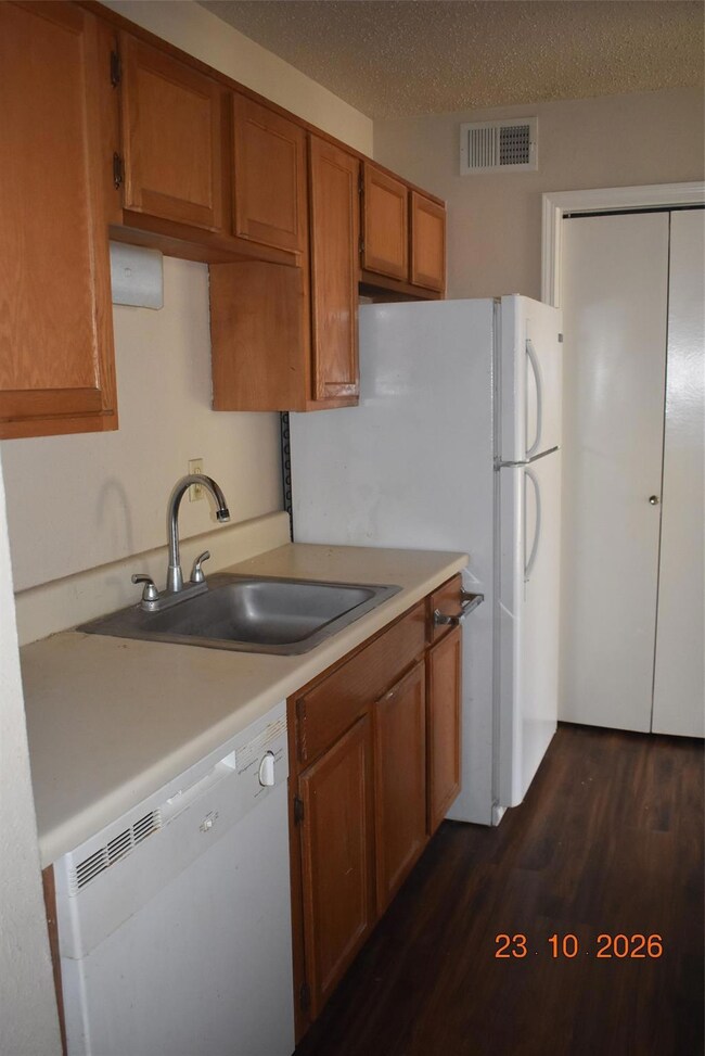 Kitchen featuring a textured ceiling, dishwashing 