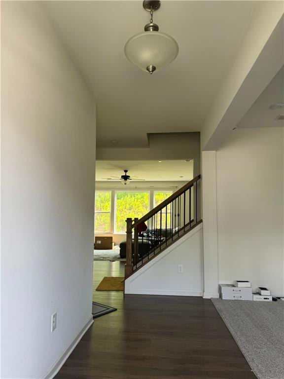 Corridor with stairs, wood finished floors, and baseboards