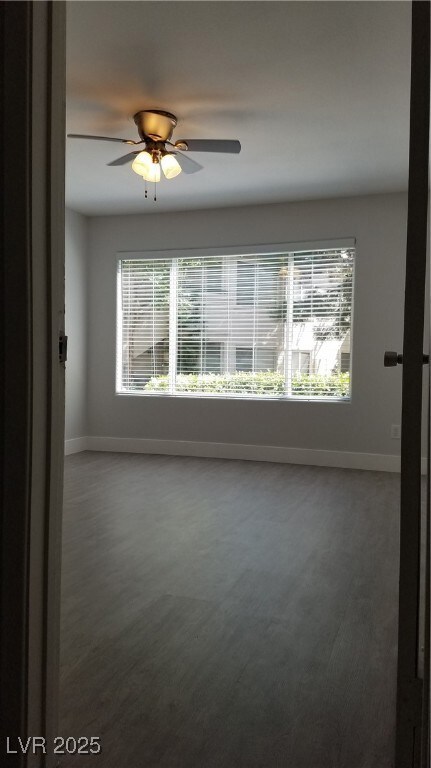 Spare room with baseboards and a ceiling fan