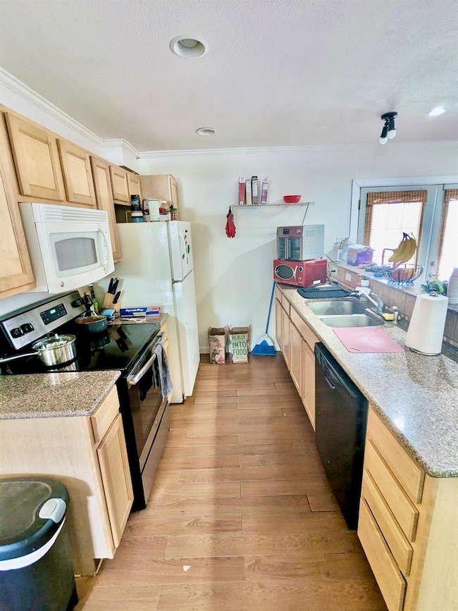 Kitchen featuring light brown cabinetry, electric