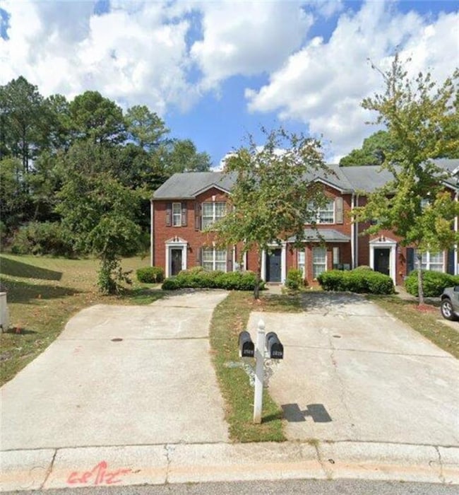Colonial inspired home featuring brick siding