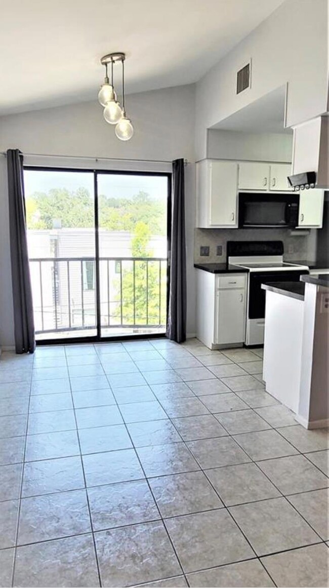 Kitchen with electric range, black microwave, dar