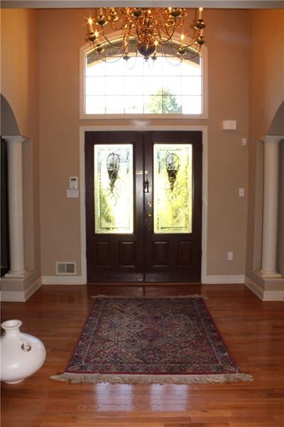 Two story foyer where hardwood floors flow through