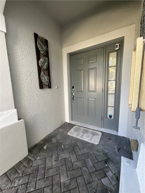 Doorway to property with stucco siding