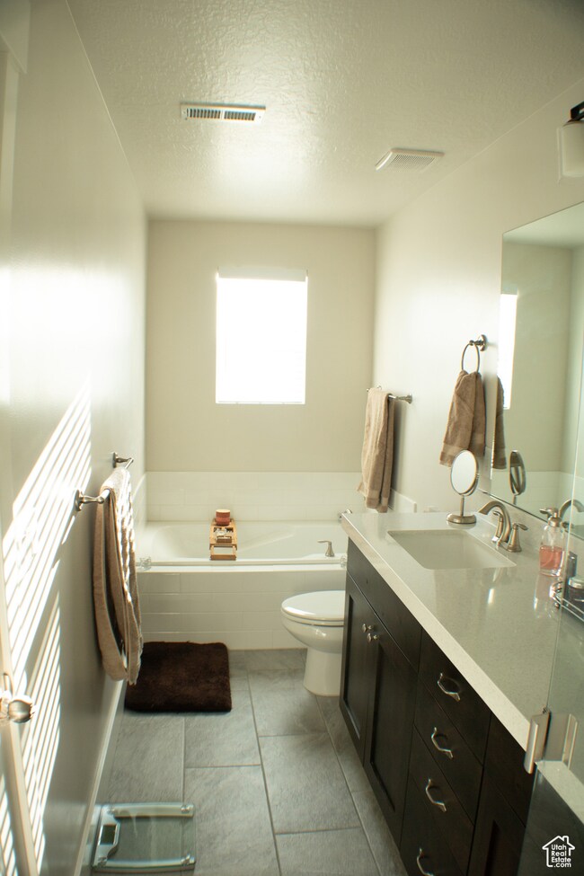 Full bathroom with a bath, vanity, and a textured ceiling