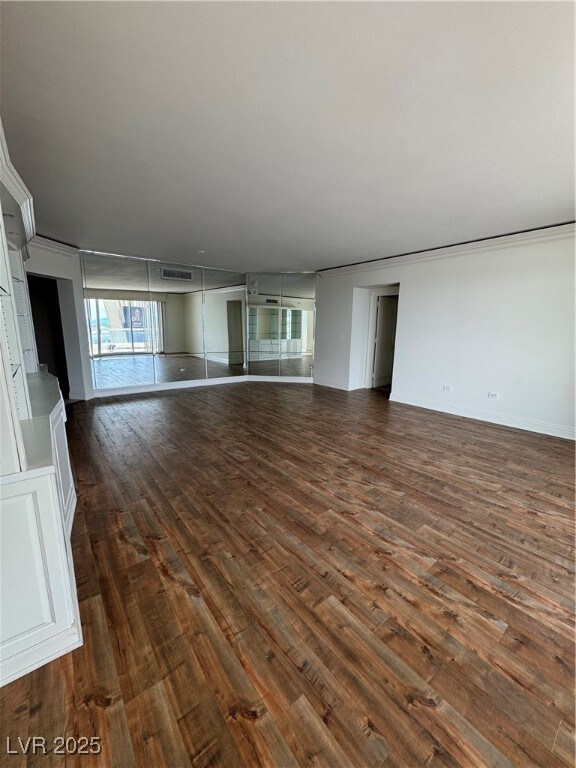 Unfurnished living room with visible vents, basebo