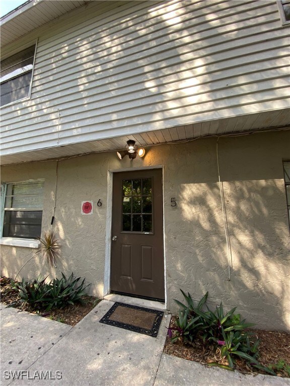 Entrance to property with stucco siding