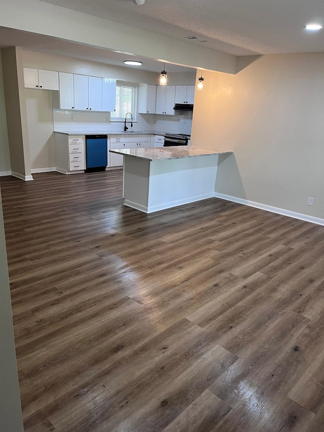 Kitchen featuring dishwasher, a peninsula, baseboa