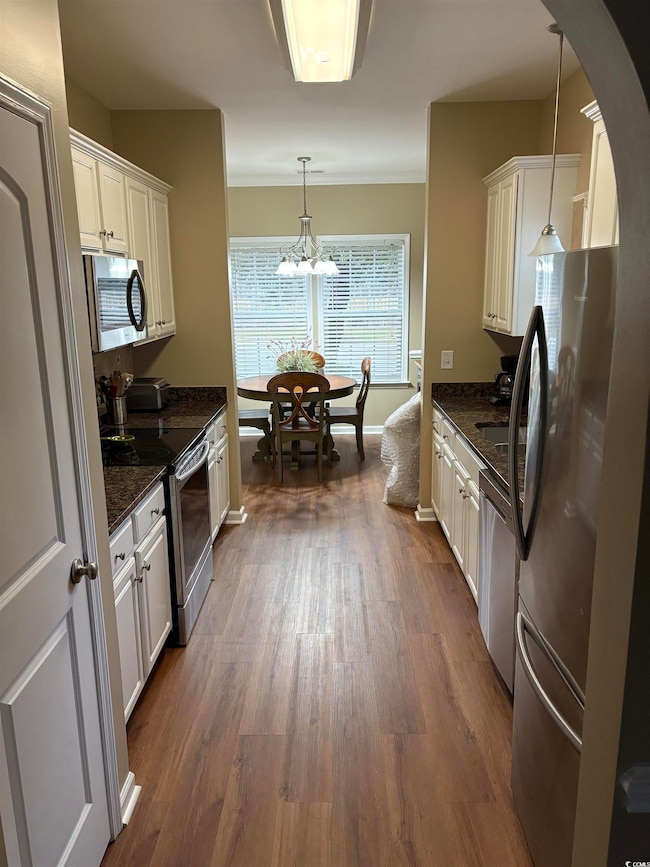 Kitchen with dark stone countertops, appliances wi