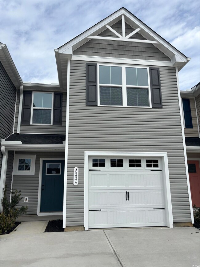 View of front of house featuring a garage and conc