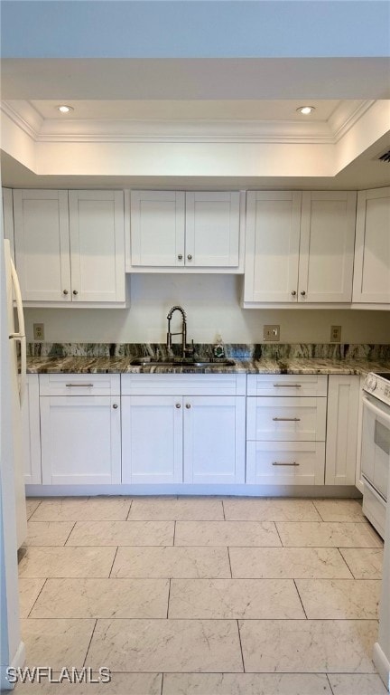 Kitchen with a raised ceiling, white appliances, a